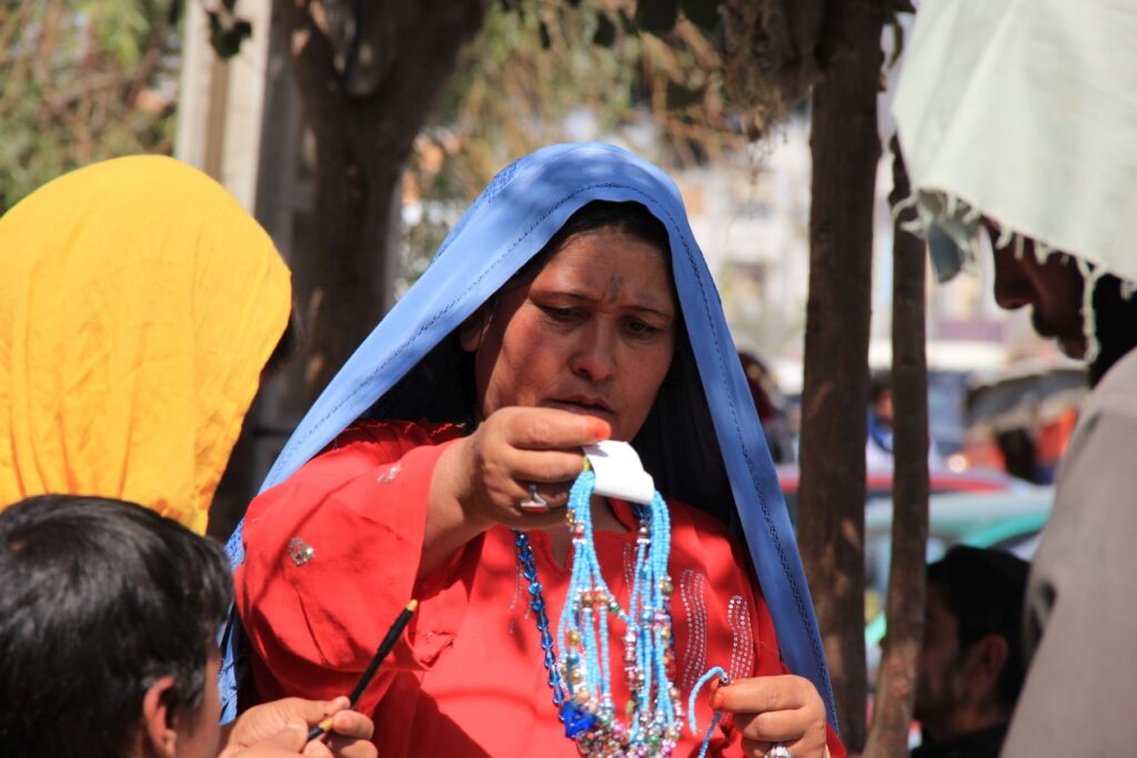 زنی در کنار خیابان با روبنده بالا از زیورآلات ( بدلی) برای دخترش انتخاب میکند. Foto: Parwiz Rahimi-2013 Herat-Afghanistan