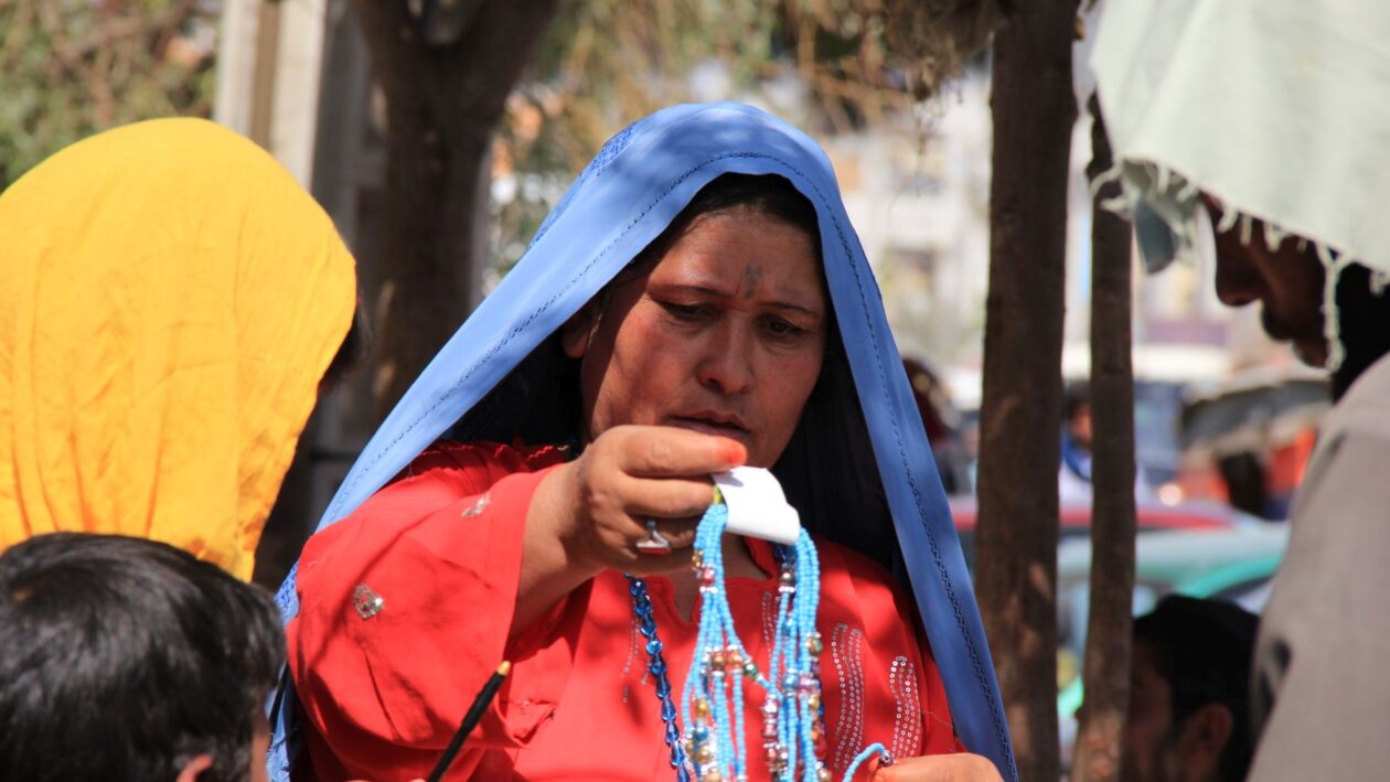 زنی در کنار خیابان با روبنده بالا از زیورآلات ( بدلی) برای دخترش انتخاب میکند. Foto: Parwiz Rahimi-2013 Herat-Afghanistan
