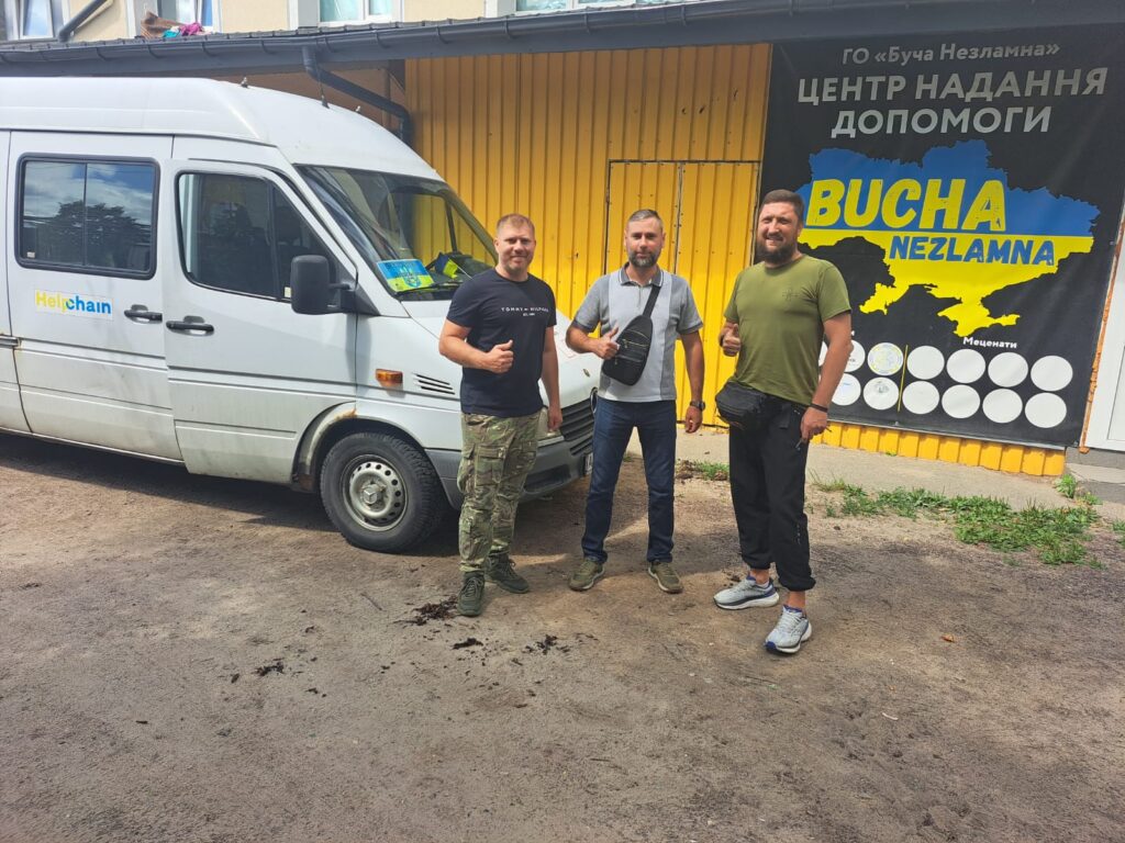 Drei Männer stehen neben einem Kleinbus.