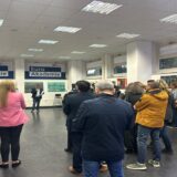 حضور وزوار يستمعون إلى كلمة افتتاح معرض جسور الضوء الفني في برلين بحضور فنانين ومهتمين.