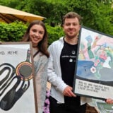Anastasiia Molodii und Nazarii Pankevych halten Poster in die Kamera.